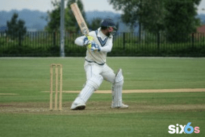 batsman playing Cricket World Cup with a bat and wickets placed on his back